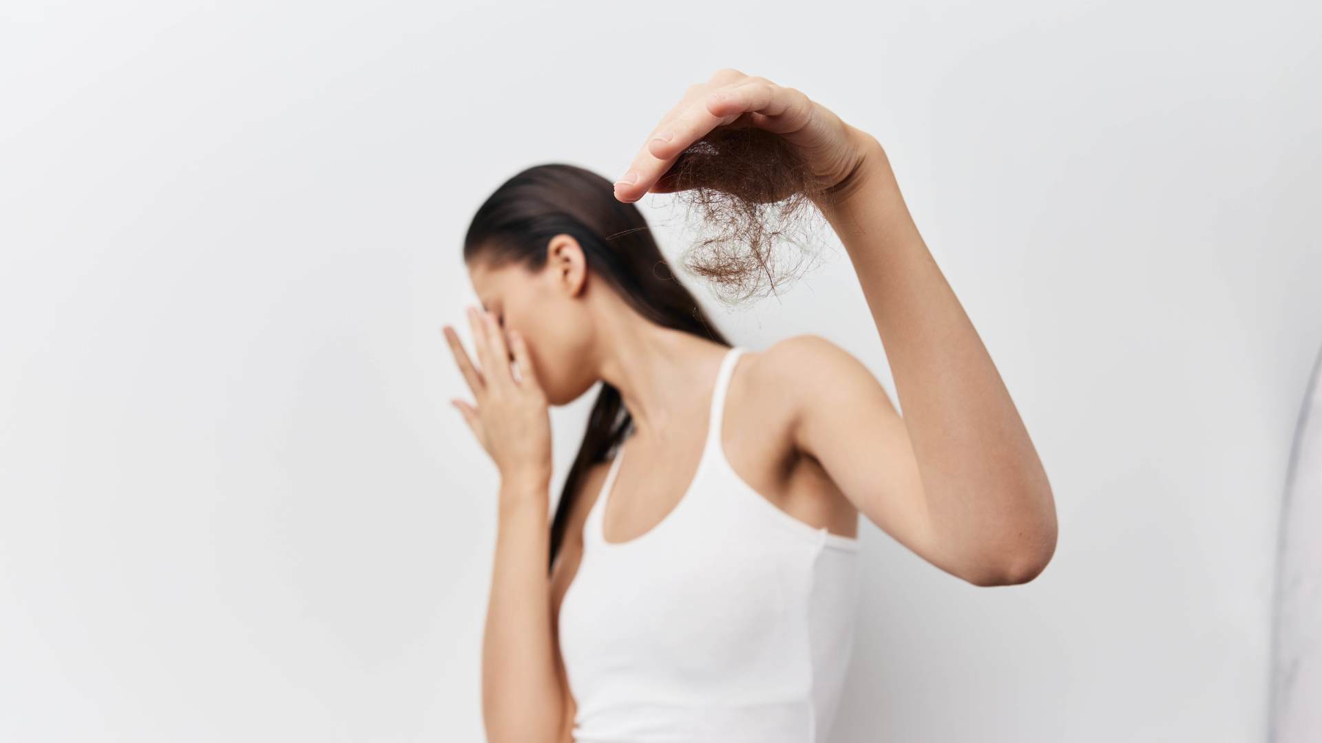 Woman holding shed hair from hair loss.