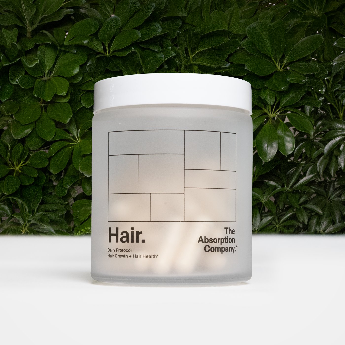 Jar of Hair against a wall of greenery